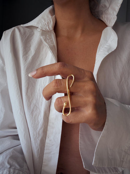A gold filled  ring with snake design. The ring features a curved, elongated shape that wraps around the fingers