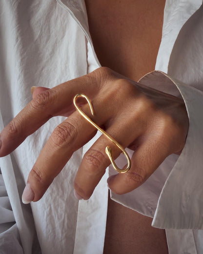 A gold filled  ring with snake design. The ring features a curved, elongated shape that wraps around the fingers