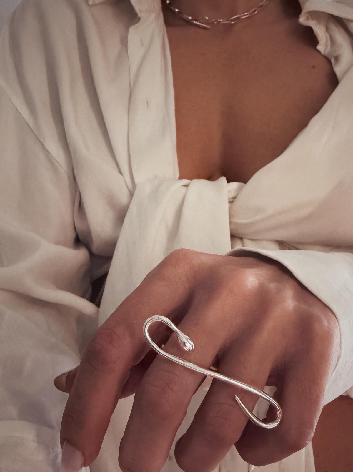 A Sterling silver 925  ring with a snake design. The ring curves over two fingers, creating an elegant and modern look.