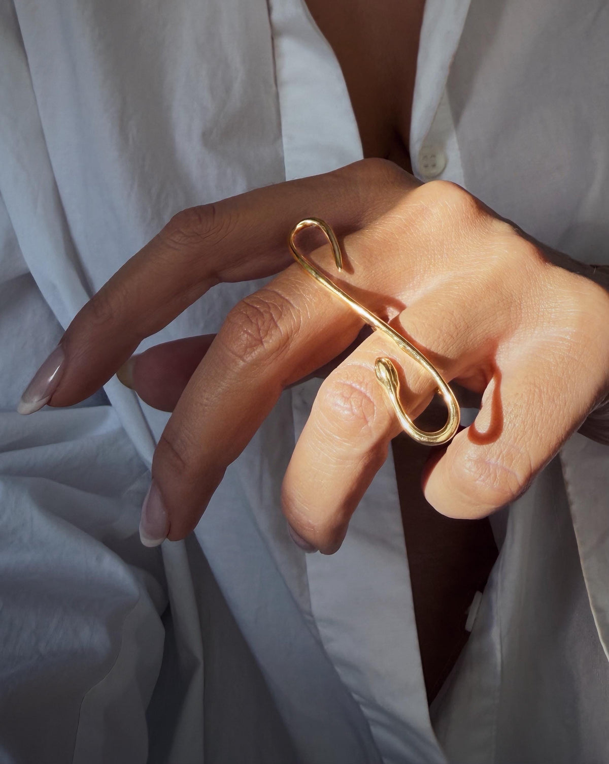 A gold filled  ring with snake design. The ring features a curved, elongated shape that wraps around the fingers