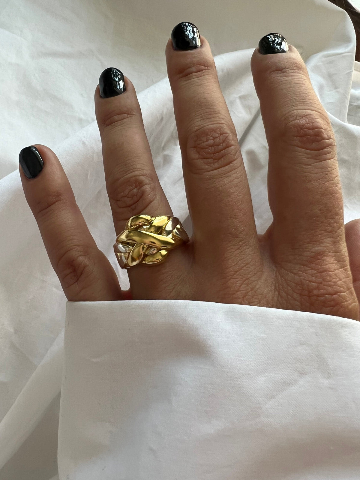 May include: A gold, silver, and white intertwined ring with a unique knot design.